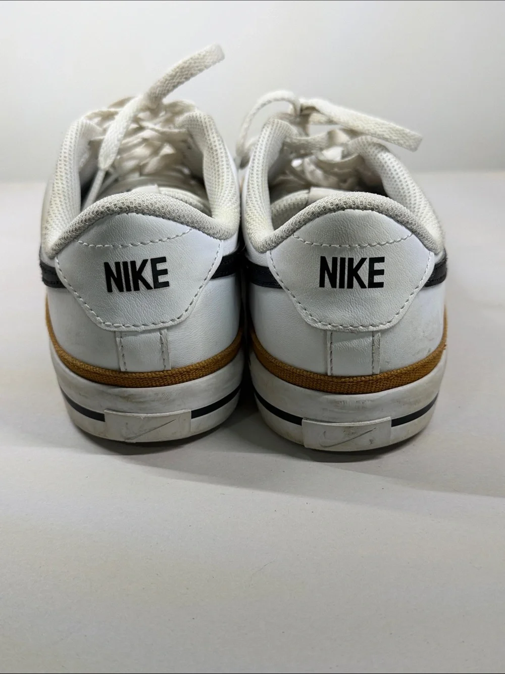 Nike White Low-Top Sneakers with Black Swoosh and Brown Trim